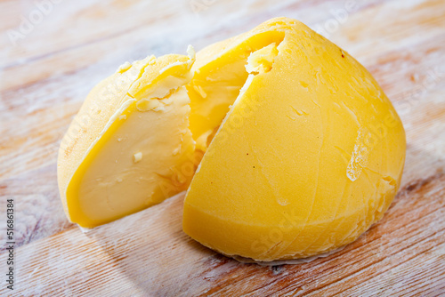 Tetilla cheese (or Perilla) from cow milk with cut piece on wooden surface. Famous cheese from Galicia photo