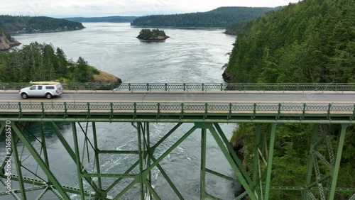 Panning aerial shot of a truck driving over the bridge at Deception Pass. photo