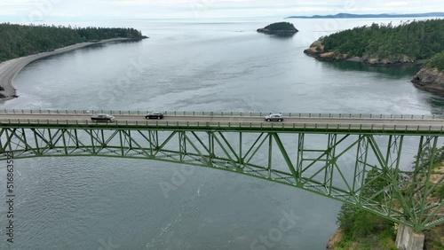 Drone perspective of cars driving across the massive bridge at Deception Pass. photo