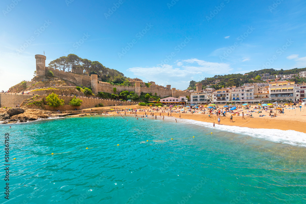 The sandy Playa Grande beach at the seaside Spanish town of Tossa de Mar, Spain, with the historic 12th Century castle above it on the Costa Brava coast.