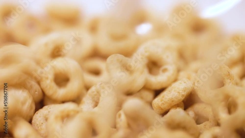 A macro of filling up a white ceramic bowl with breakfast cereal photo