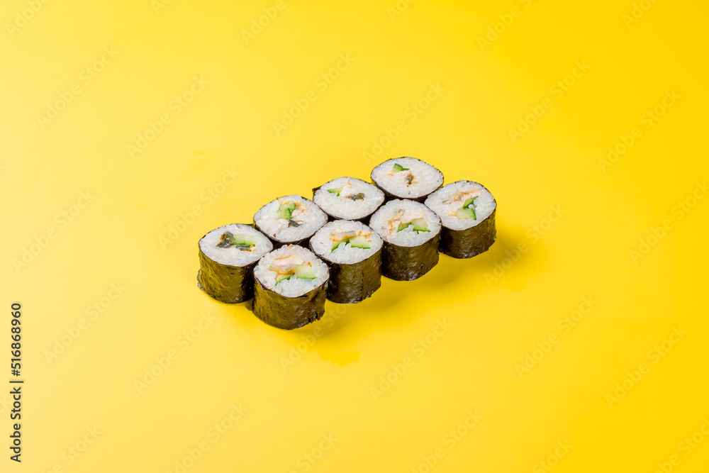 roll with cucumber and eel on yellow background roll with cucumber and eel on yellow background