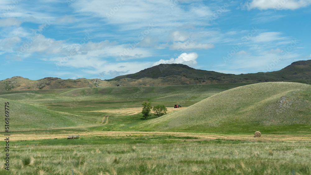 A tractor at work in the rolling green hills of western Montana.