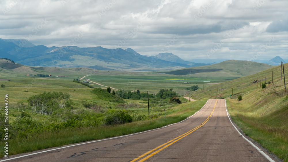 The two-lane road stretches off into the far distance in the hills of western Montana.