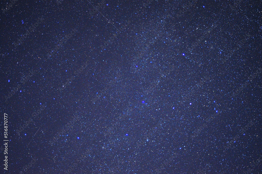 A fragment of the night starry sky with bright stars and several tracks.