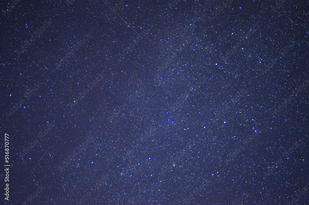 Fototapeta premium A fragment of the night starry sky with bright stars and several tracks.