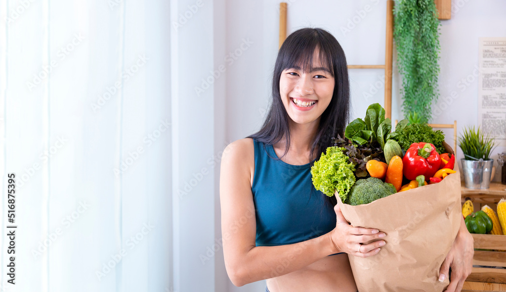Asian Japanese woman holding shopping bag from supermarket full of organics vegetables and fruits for healthy food and vegetarian salad with copy space Asian Japanese woman holding shopping bag from supermarket full of organics vegetables and fruits for healthy food and vegetarian salad with copy space