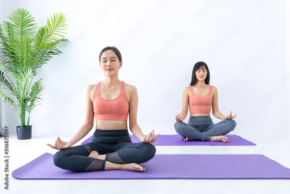 Asian woman practicing yoga indoor with easy and simple position to control breathing in and out in meditation pose Asian woman practicing yoga indoor with easy and simple position to control breathing in and out in meditation pose