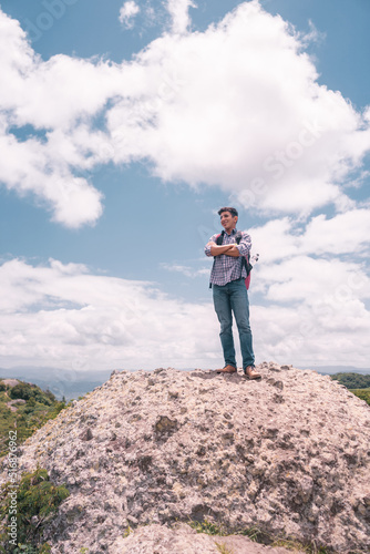Latin college student on a hill with his arms crossed looking at the sky in Jinotega Nicaragua