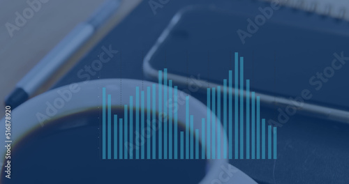 Image of graph processing data over notebook  smartphone and coffee cup on desk