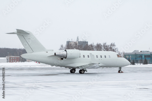 White luxury executive aircraft on the winter airport apron