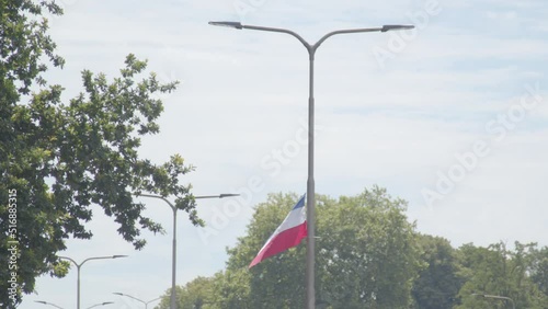 Tilting down to Upside down flag waving on lamp poast at busy road. A sign of the Dutch farmer protests which are happening all over the Netherlands photo