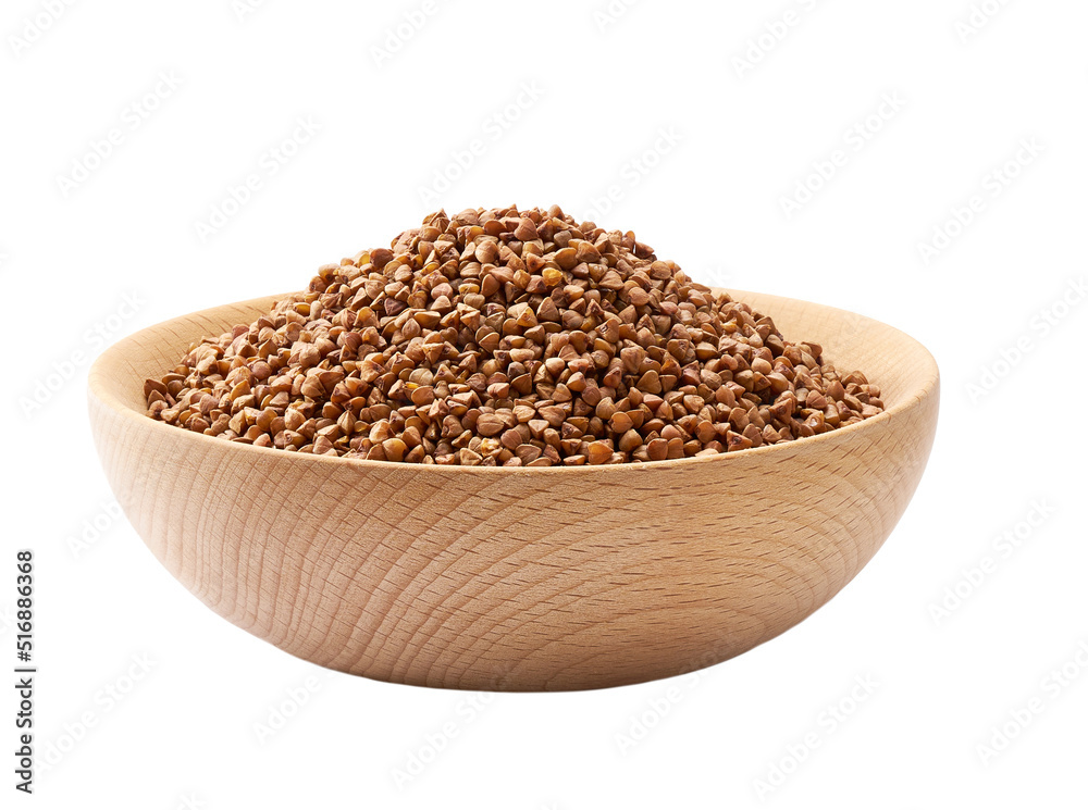 Raw buckwheat in a wooden bowl isolated on white background. Raw buckwheat in a wooden bowl isolated on white background.
