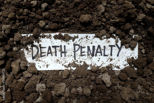 Obraz na płótnie Death penalty concept. Written word on paper under soil.
w salonie