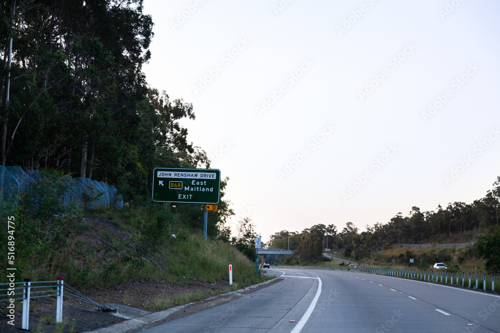 East Maitland exit off highway sign at dusk along Hunter expressway M15 East Maitland exit off highway sign at dusk along Hunter expressway M15