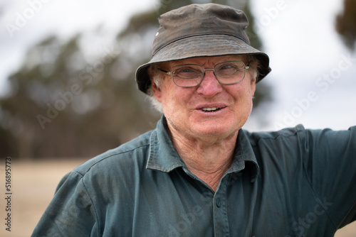 man in his sixties wearing workwear happily glancing away photo