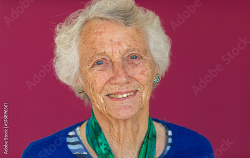 head and shoulders of elderly lady with grey hair looking at camera