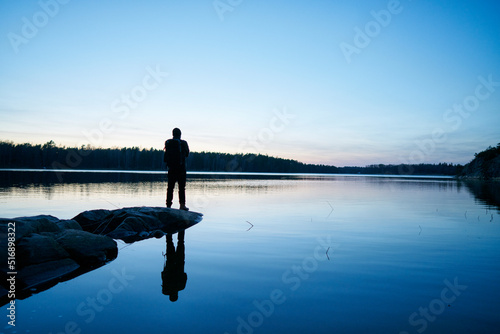 Silhouette of man by sea at sunset in Bjorno Sweden
