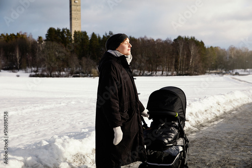 Woman with stroller in park during winter photo