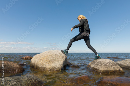 Woman walking on rocks in Lake Vanern Sweden photo