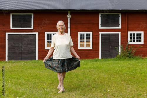 Senior woman doing curtsy by house Fototapet