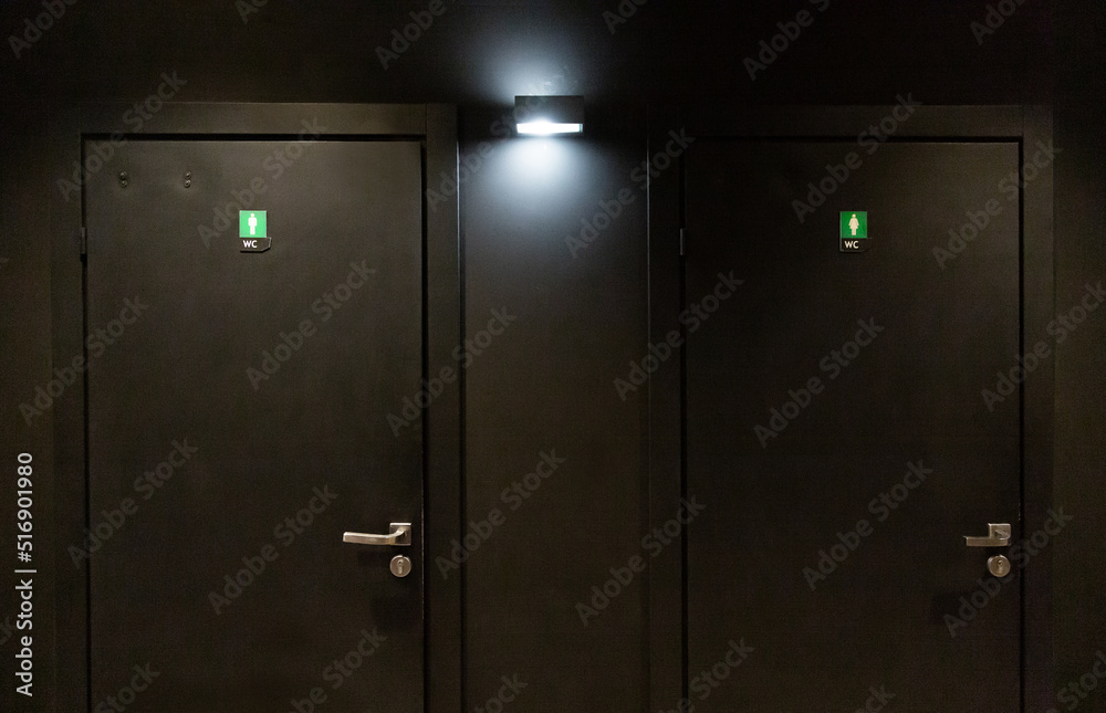 Black door in the dressing room in a nightclub. Toilet for men and women. Black door in the dressing room in a nightclub. Toilet for men and women.