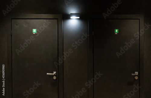 Black door in the dressing room in a nightclub. Toilet for men and women.