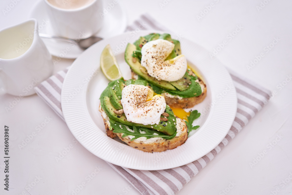 Freshly made poached egg and Avocado toasts on light grey background Freshly made poached egg and Avocado toasts on light grey background