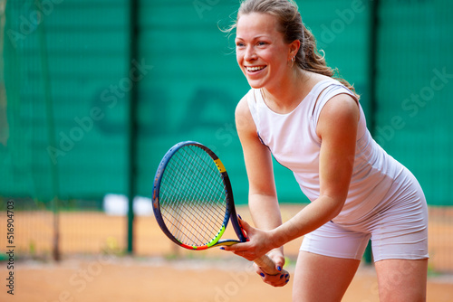 Female tennis player holding the racket while waiting for serve. © Dmytro Panchenko