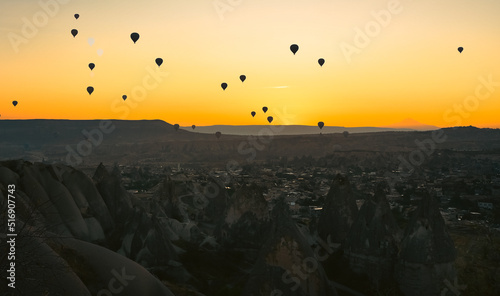Early morning in the valley with rocks and balloons in the sky at dawn. Cappadocia. Turkey.Selective focus on balloons in the sky.