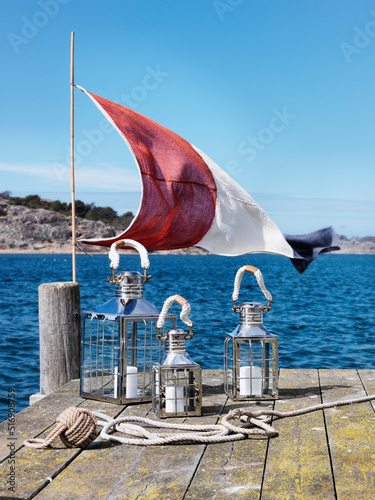Flag and lanterns on jetty by sea photo