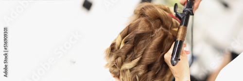 Blonde female on hairdresser appointment get curly hairstyle