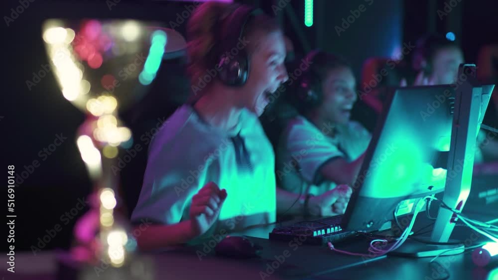 Handheld, female gamers in headphones, plays a video game, cyber sportsmans at the game, communication between players, the team won the round, emotions of victory, tournament. Handheld, female gamers in headphones, plays a video game, cyber sportsmans at the game, communication between players, the team won the round, emotions of victory, tournament.
