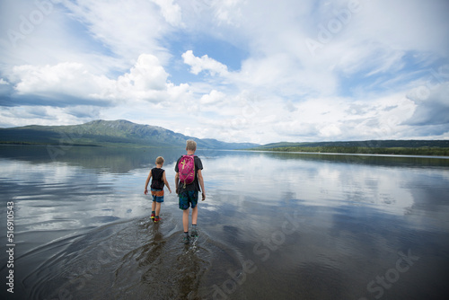 Brother wading across Ottsjo Lake in Valadalen Nature Reserve Sweden photo