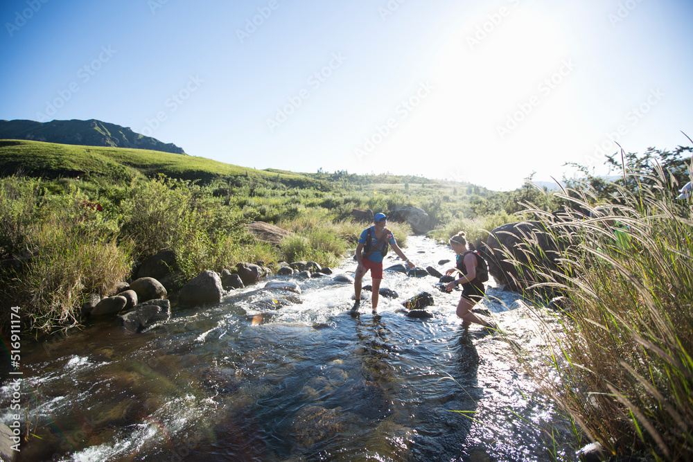 Couple crossing river during hike Couple crossing river during hike