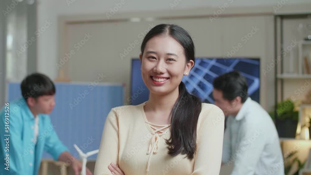 Close Up Of Smiling Asian Woman Engineer Crossing Her Arms To Camera While Her Colleagues Are Discussing About Work Of Solar Cell At The Office
Close Up Of Smiling Asian Woman Engineer Crossing Her Arms To Camera While Her Colleagues Are Discussing About Work Of Solar Cell At The Office