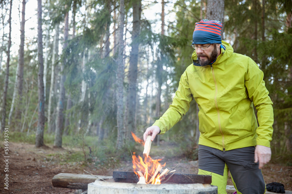 Man lighting campfire in forest Man lighting campfire in forest