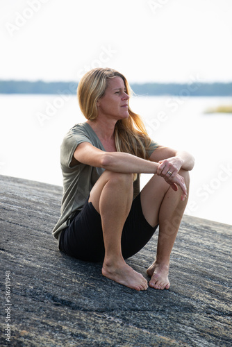 Woman sitting on rock by sea photo