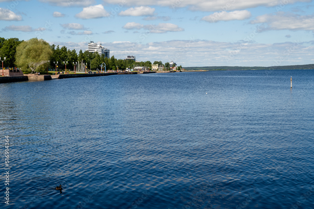 Landscape overlooking the lake on a clear sunny day. Lake Onega with the embankment of the city of Petrozavodsk, Karelia, Russia. The concept of tourism in Russia. Landscape overlooking the lake on a clear sunny day. Lake Onega with the embankment of the city of Petrozavodsk, Karelia, Russia. The concept of tourism in Russia.