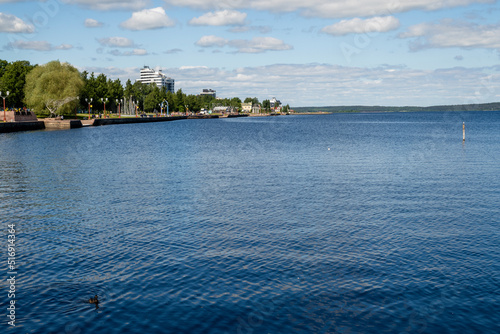 Landscape overlooking the lake on a clear sunny day. Lake Onega with the embankment of the city of Petrozavodsk, Karelia, Russia. The concept of tourism in Russia. © Elena Tcykina