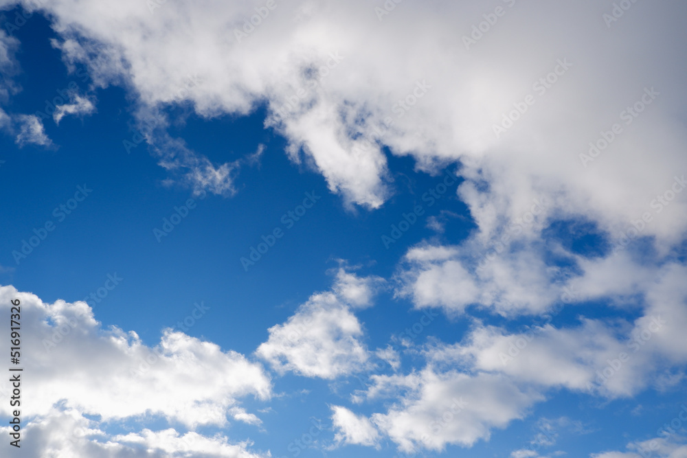 Sky with clouds and sun. White colour clouds against blue sky