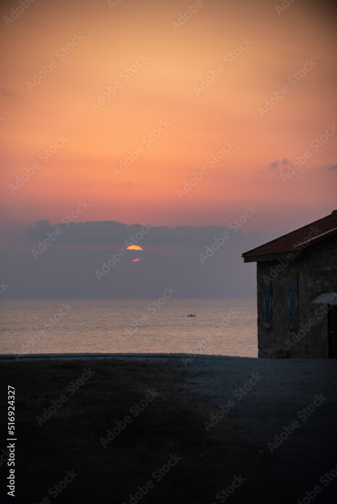 Beautiful sunset at the lighthouse of Kato Paphos coastline.