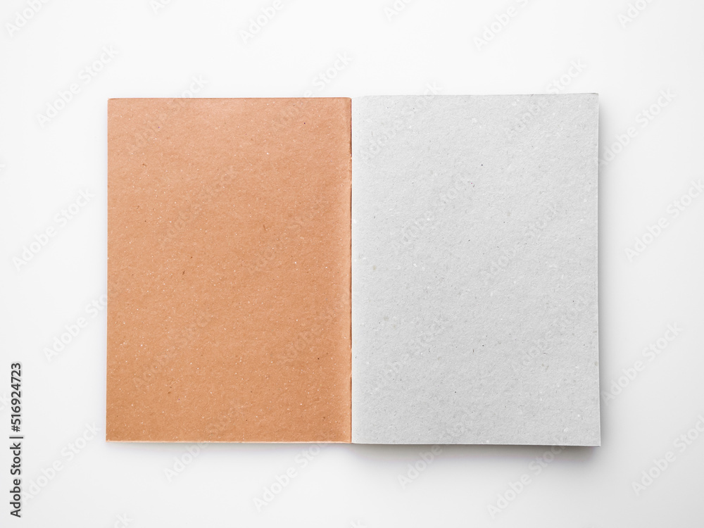 open vertical notepad with brown craft cover and gray sheets on white table open vertical notepad with brown craft cover and gray sheets on white table