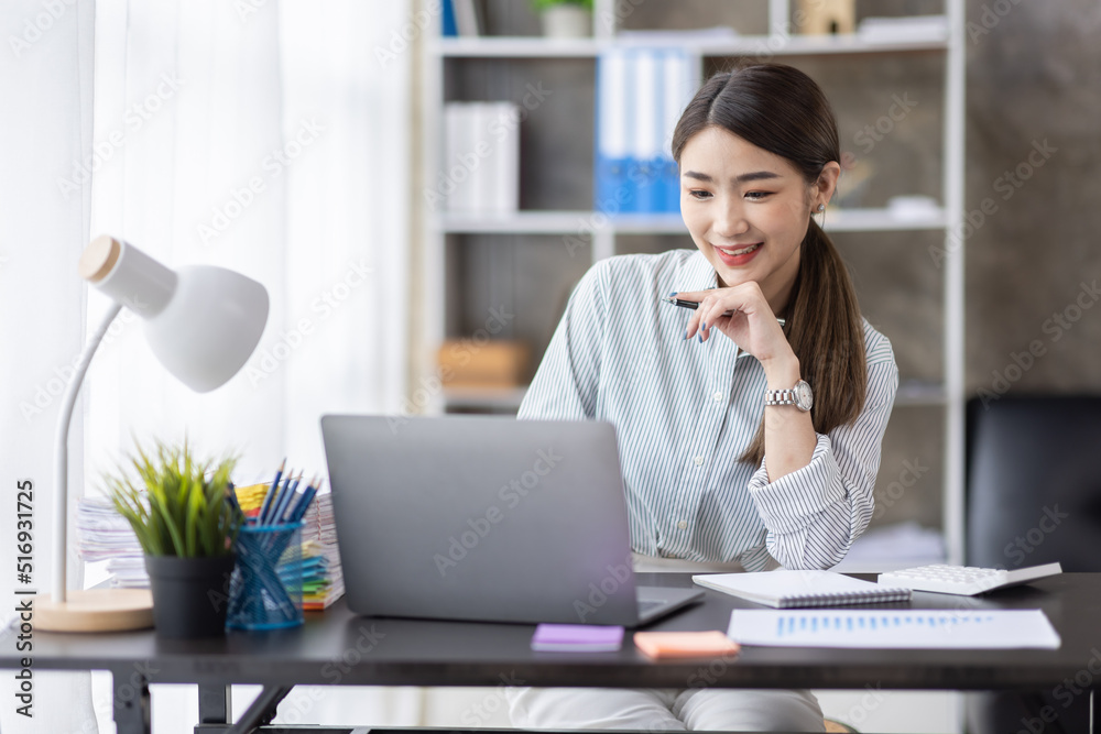 Business of Asian woman or accountant working on calculator to calculate business data, accounting document, and laptop computer at home office, business finances and calculate concept Business of Asian woman or accountant working on calculator to calculate business data, accounting document, and laptop computer at home office, business finances and calculate concept