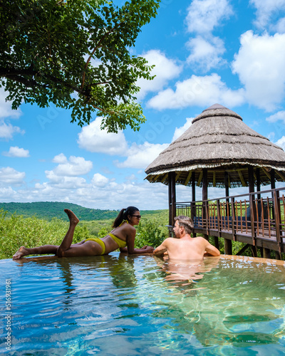 South Africa Kwazulu natal, a luxury safari lodge in the bush of a Game reserve Savanah, couple man and woman at the swimming pool, men and Asian woman at the infinity pool photo
