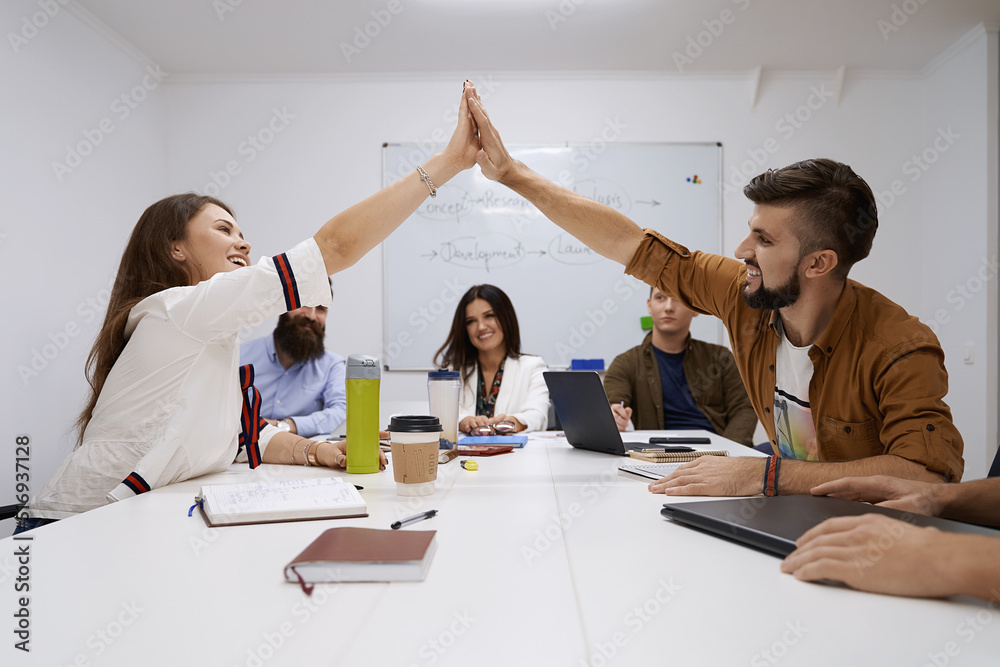 Happy team giving hightfive. Celebrating success with hi five. Coworkers friends touching hands after completed the work perfectly.