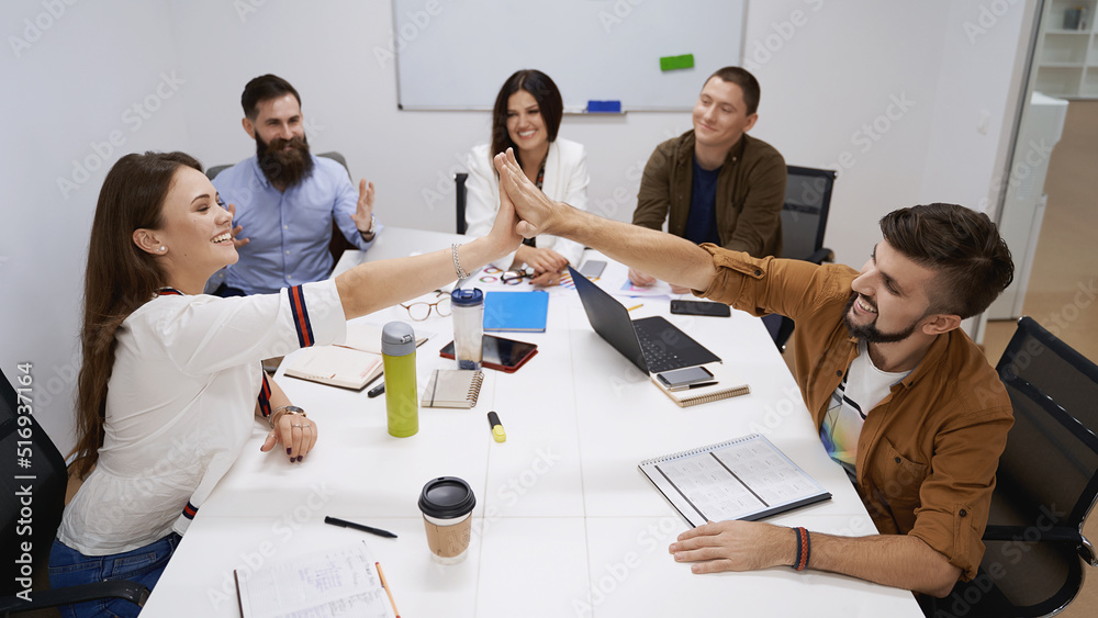Happy team giving hightfive. Celebrating success with hi five. Coworkers friends touching hands after completed the work perfectly.