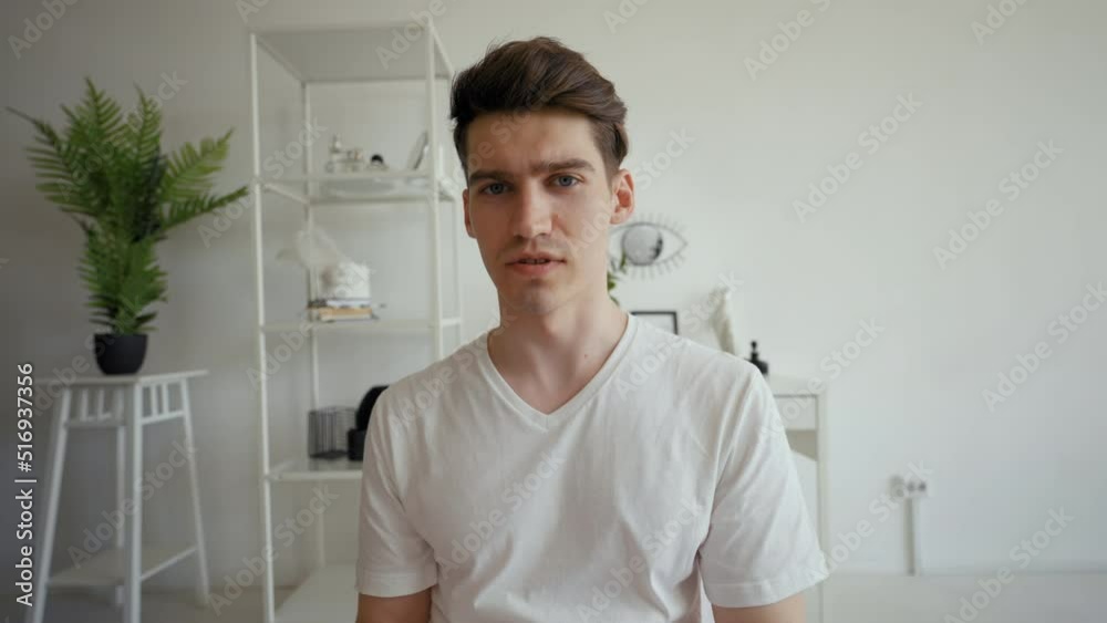 POV of young man taking online exam on video call from home. Male student sits in modern living room speaking and looking in camera close view POV of young man taking online exam on video call from home. Male student sits in modern living room speaking and looking in camera close view