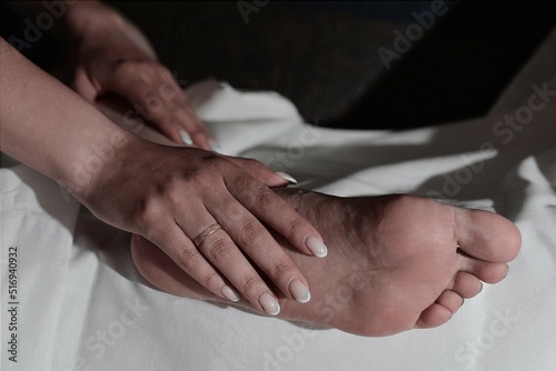 Arms and legs on a white cloth. Human toes and foot. Relationships of people. Woman in bed 