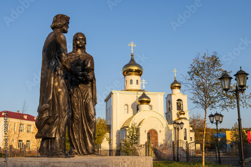 Monument to Saints Peter and Fevronia of Murom and the Church of the Transfiguration of the Lord, urban-type settlement of Palatka, Magadan region, Far East of Russia. Tourist architectural sights. photo